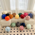 Plush knot cushions in many colours on sofa