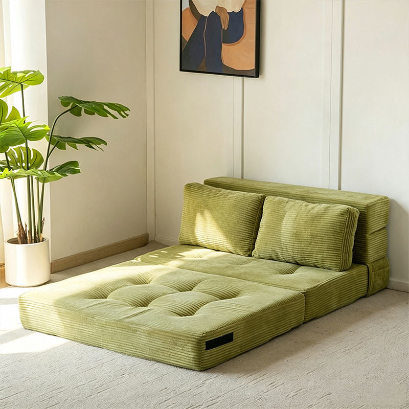 Green corduroy convertible sofa bed opened into a lounge bed