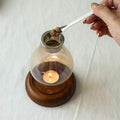 Glass candle and incense holder with wooden base in use