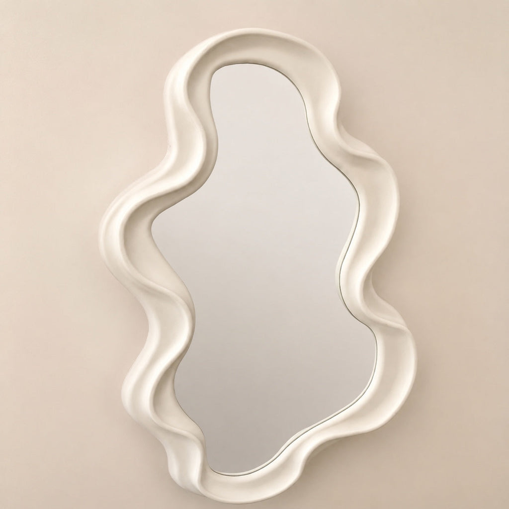 Ivory irregular wave edge mirror against beige wall