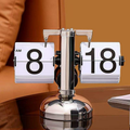Retro silver flip clock with white number cards styled on a table